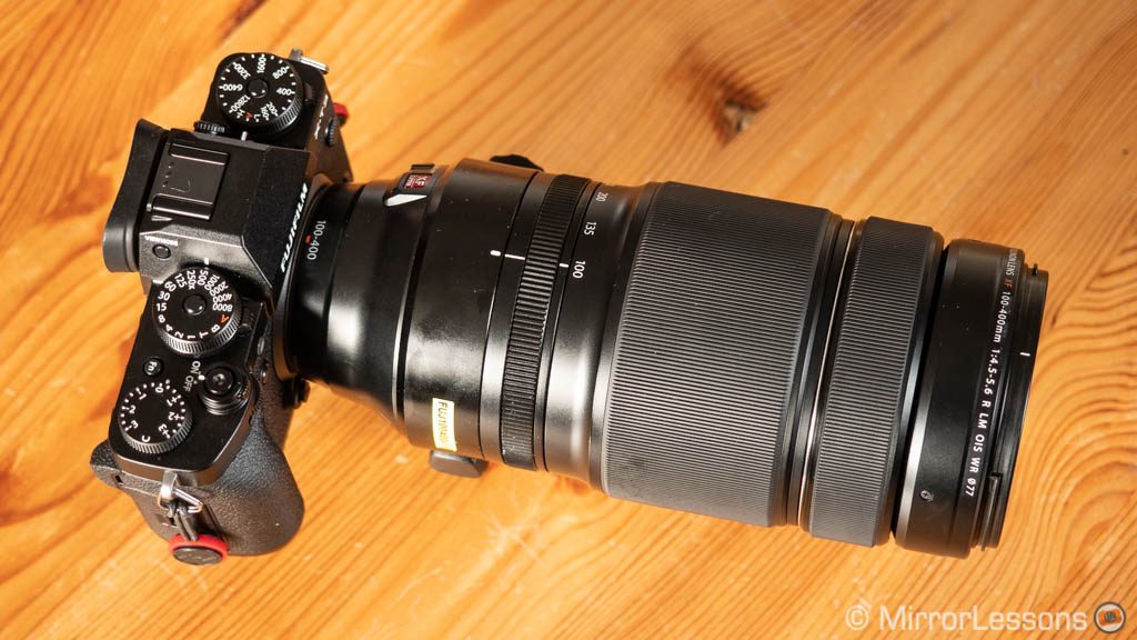 fuji XT3 with 100-400mm lens attached on a wooden surface, view from above