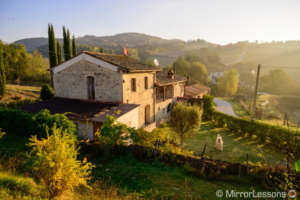 farm on a hill at sunrise in the Italian countryside