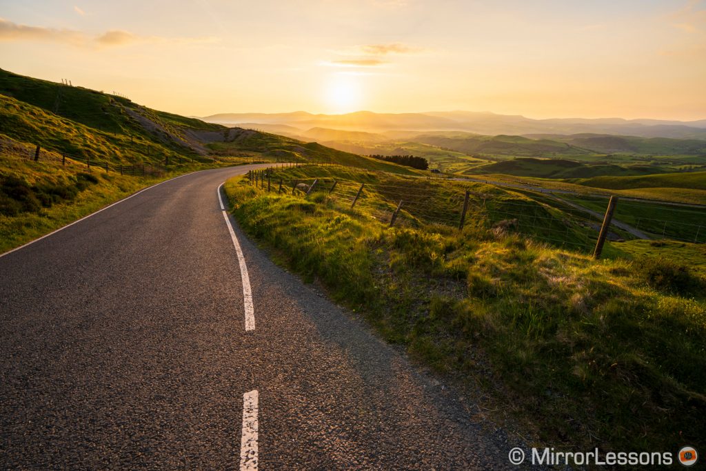 country road and view on the hills at sunset