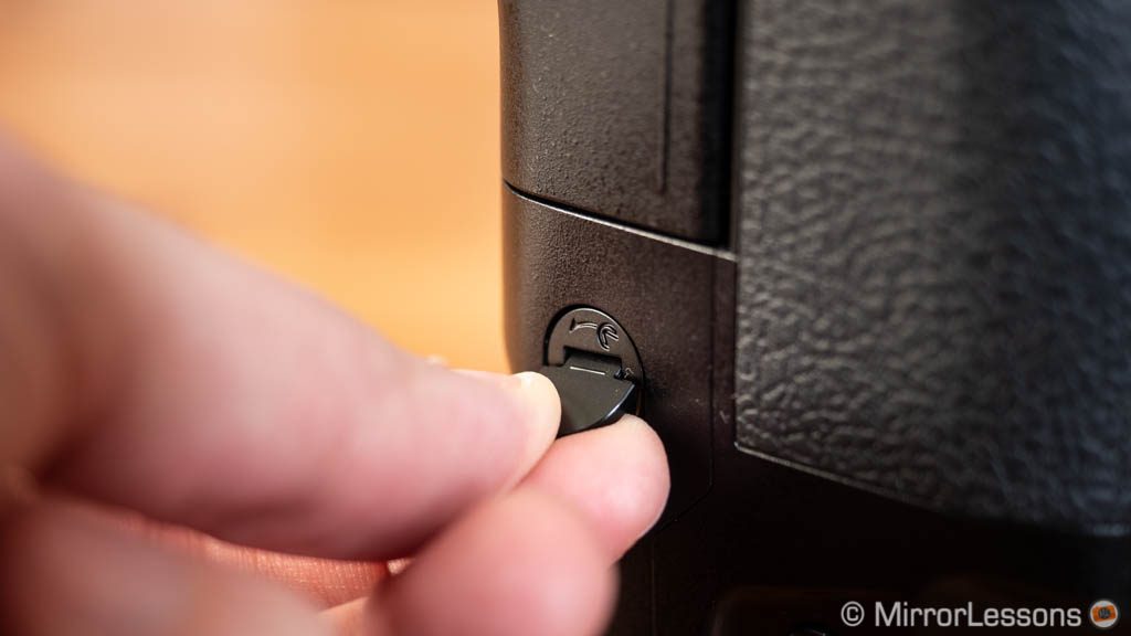 The lever on the E-M1X to unlock the card slots