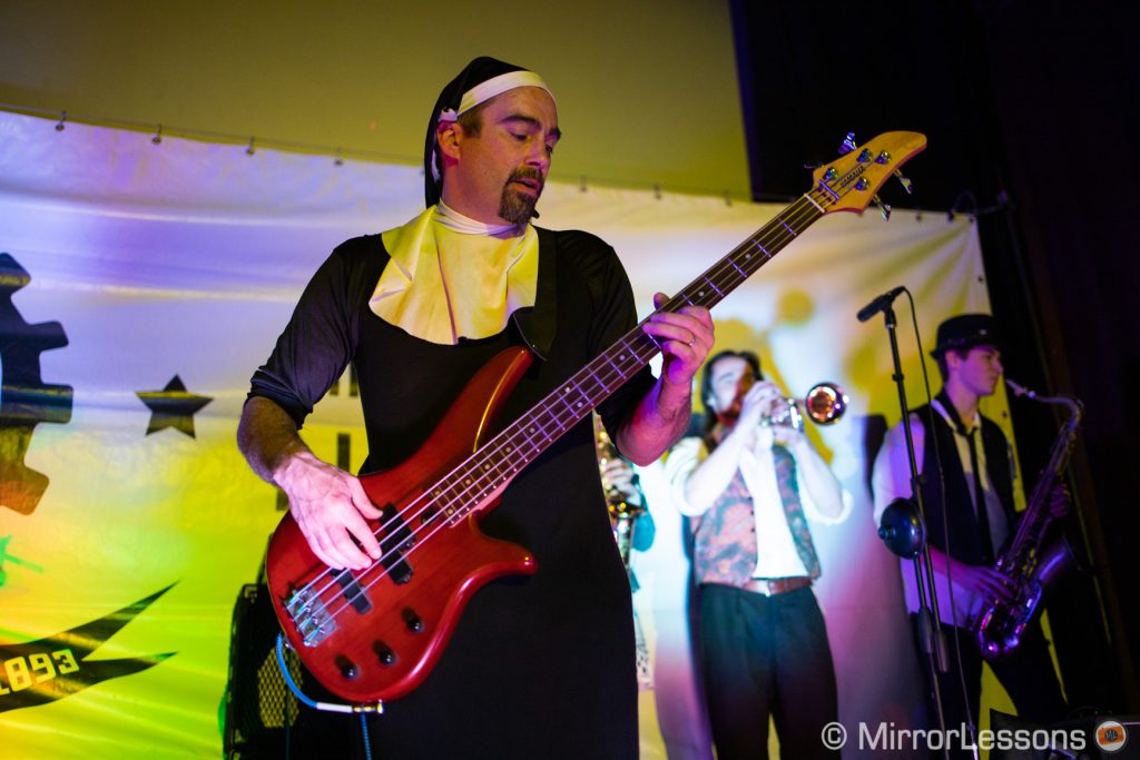 bass player dressed as a nun playing at a rock concert