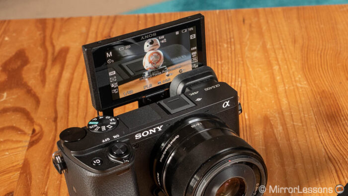 sony a6400 on a wooden table, with the lcd screen titled up