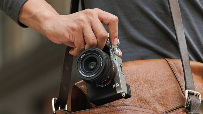 male hand pulling the A7C out of a leather bag