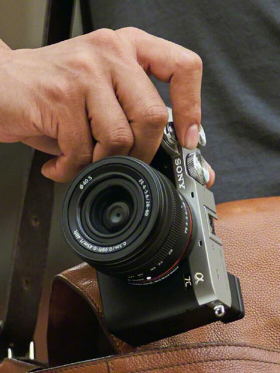 male hand pulling the A7C out of a leather bag