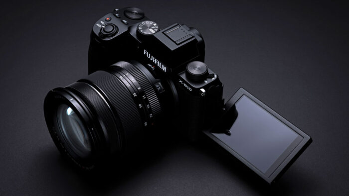 Fujifilm X-S10 on black background, with LCD monitor opened on the side