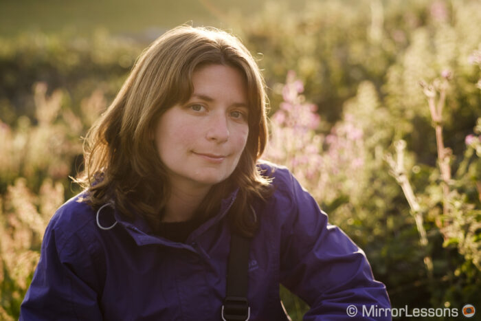 portrait of a woman taken outdoor with backlit flowers in the background using the samyang 50mm f1.2