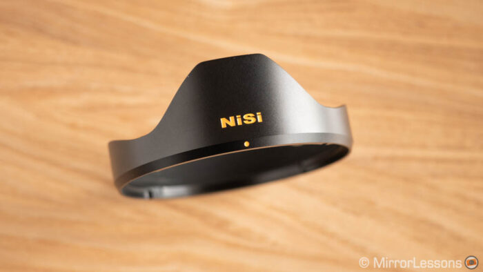 metal lens hood of the Nisi 15mm resting on a wooden surface