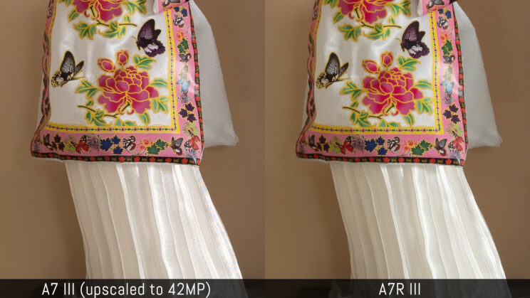 side by side crop of the Japanese doll, the A7 iii version on the left is upscaled to 42MP