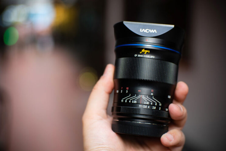 hand holding the Laowa 33mm lens with blurred background