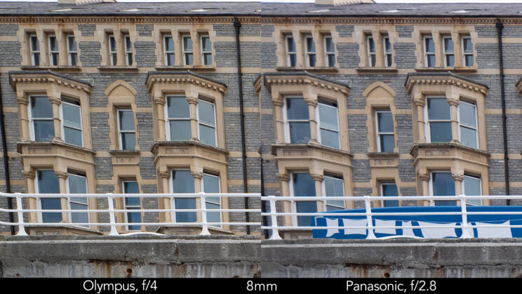 side by side enlargement of top left corner (details of the buildings) showcasing the quality at 8mm and f2.8 for the Panasonic lens, f4 for the Olympus