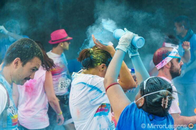 colour run member spraying runners with coloured powder