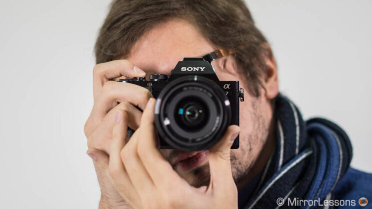 Male photographer taking a picture with the Sony A7 and pointing straight to the camera