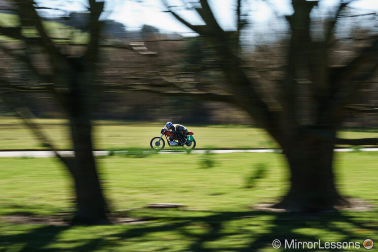 racing biker speeding on the track with trees in the foreground