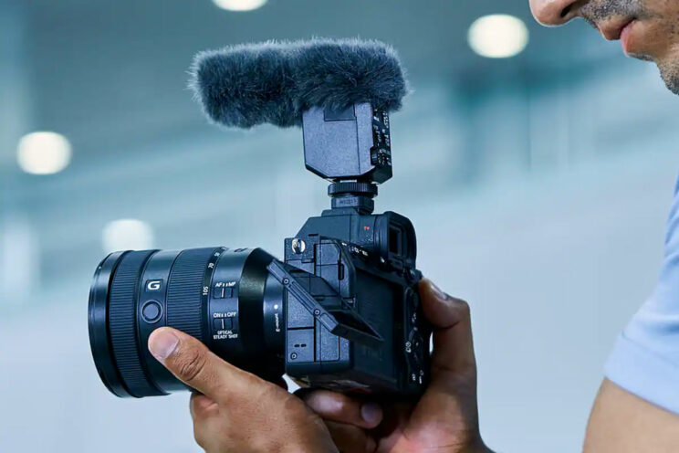 Cameraman holding the A7 IV with lens and microphone