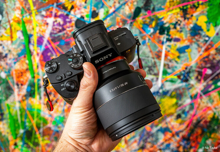 male hand holding the Samyang 50mm mounted on the A7 III