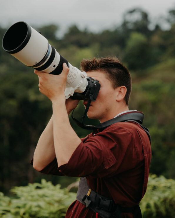 male photographer taking pictures with the OM-1 and 150-400mm Pro lens