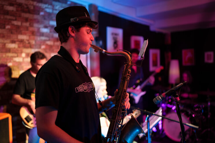 Sax player with other musicians in the background