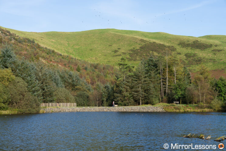 Landscape image with green hill and blue lake